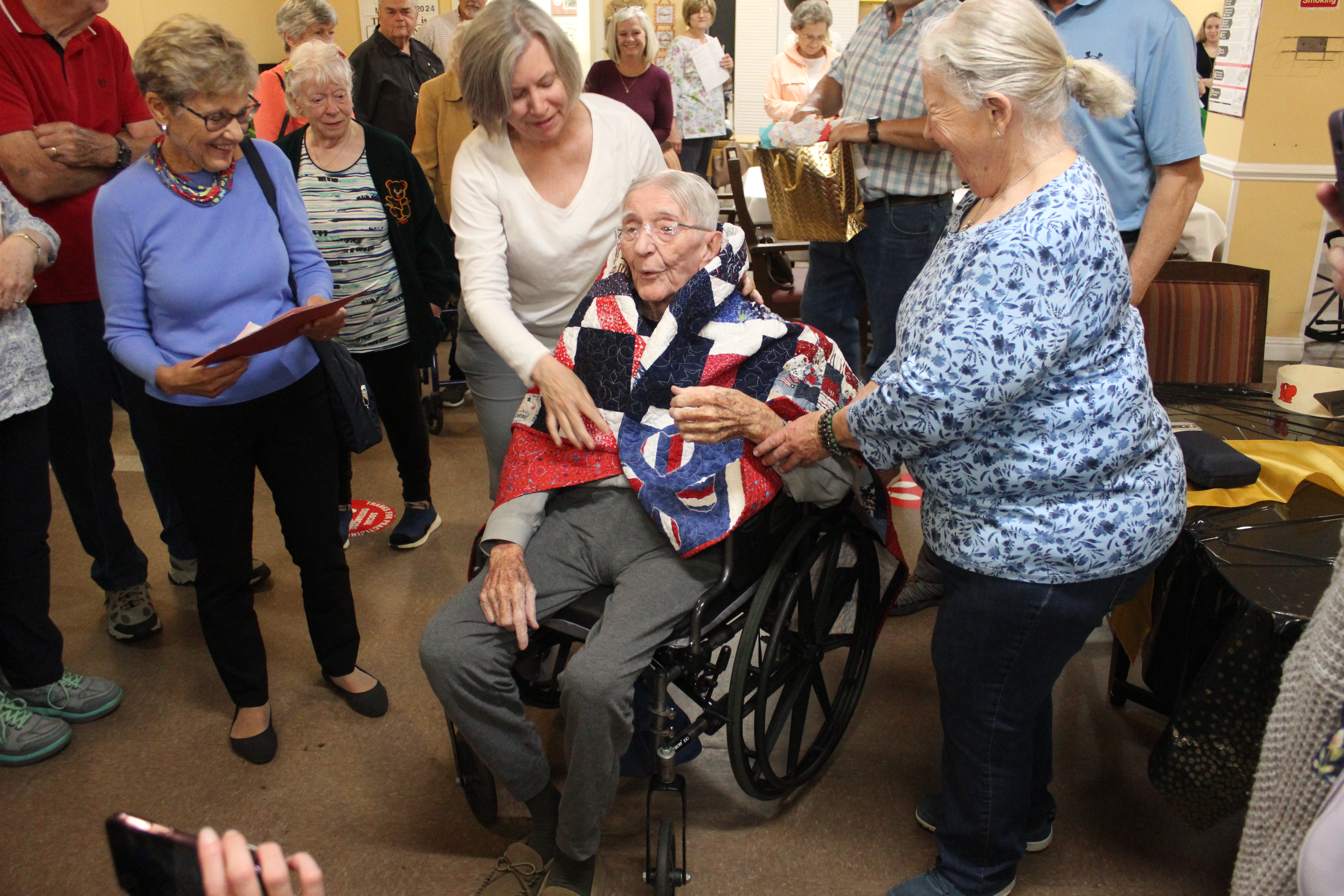 From left, Smoky Mountain Quilters Becky Painter, Janet McDonald and Margaret Varner present Arnold Price with a Quilt of Valor during a celebration for his 100th birthday.
