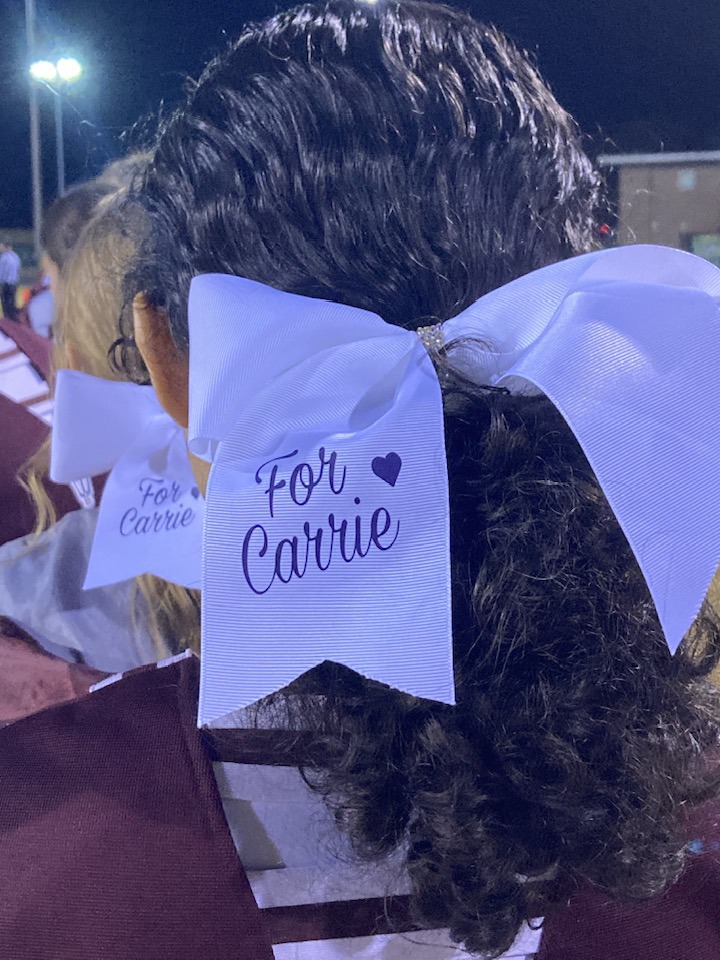 Swain Lady Devils cheer team wore hair ribbons that read “For Carrie” in memory of athletic director Carrie Powell.