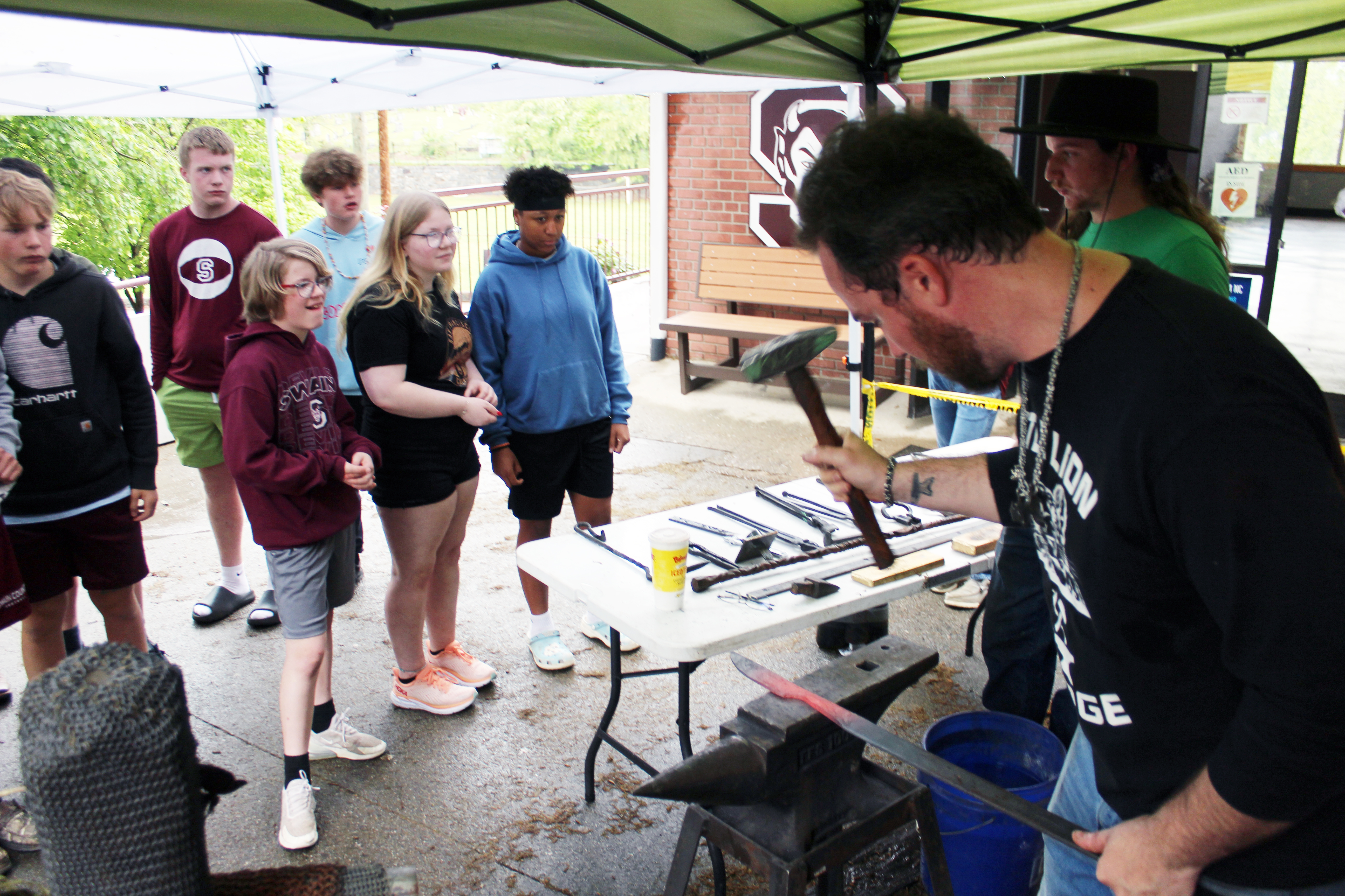 Jesse Bolding and Peyton Smith, artists at Jackson County Green Energy Park, were encouraging students to ask questions as Bolding hammers a chisel. Draven Shanks (front row first from left) was among the students who asked questions.