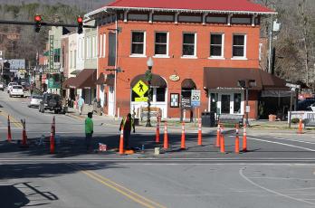 Contractors with Teraflex continue work on the water and sewer lines on Main Street with one man emerging from the manhole on the street.