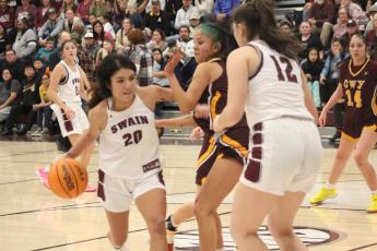 Lady Devils senior Triniti Littlejohn (from left) and sophomore Carley Teesateskie grapple with a Lady Braves athlete over the ball at the game Friday, Jan. 5.