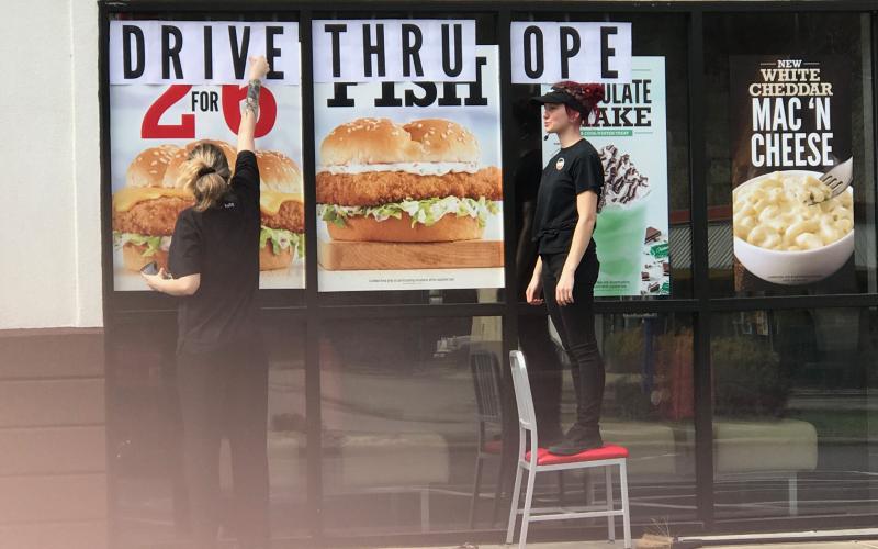 Employees at Arby's post a sign on the window that reads "Drive Thru Open" following Gov. Roy Cooper's order last week that restaurants can no longer have dine-in service. It's one of many measures the government has put in place to try to stop the spread of coronavirus. 