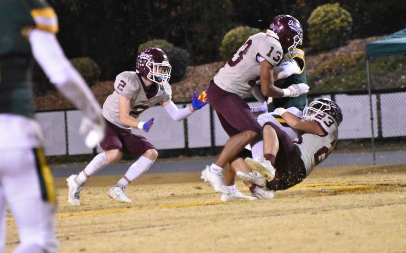 From left, Maroon Devils Corey Stilwell, Josiah Glaspie and Skeet Cook step up the defense in the win over Bessemer City Friday night.