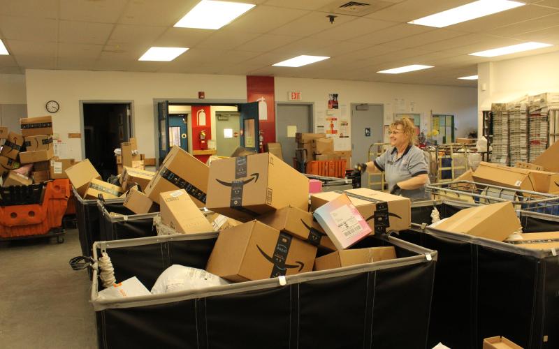 Postal worker Angie Gibby sorts through the numerous package deliveries ready to go out in mid-December.