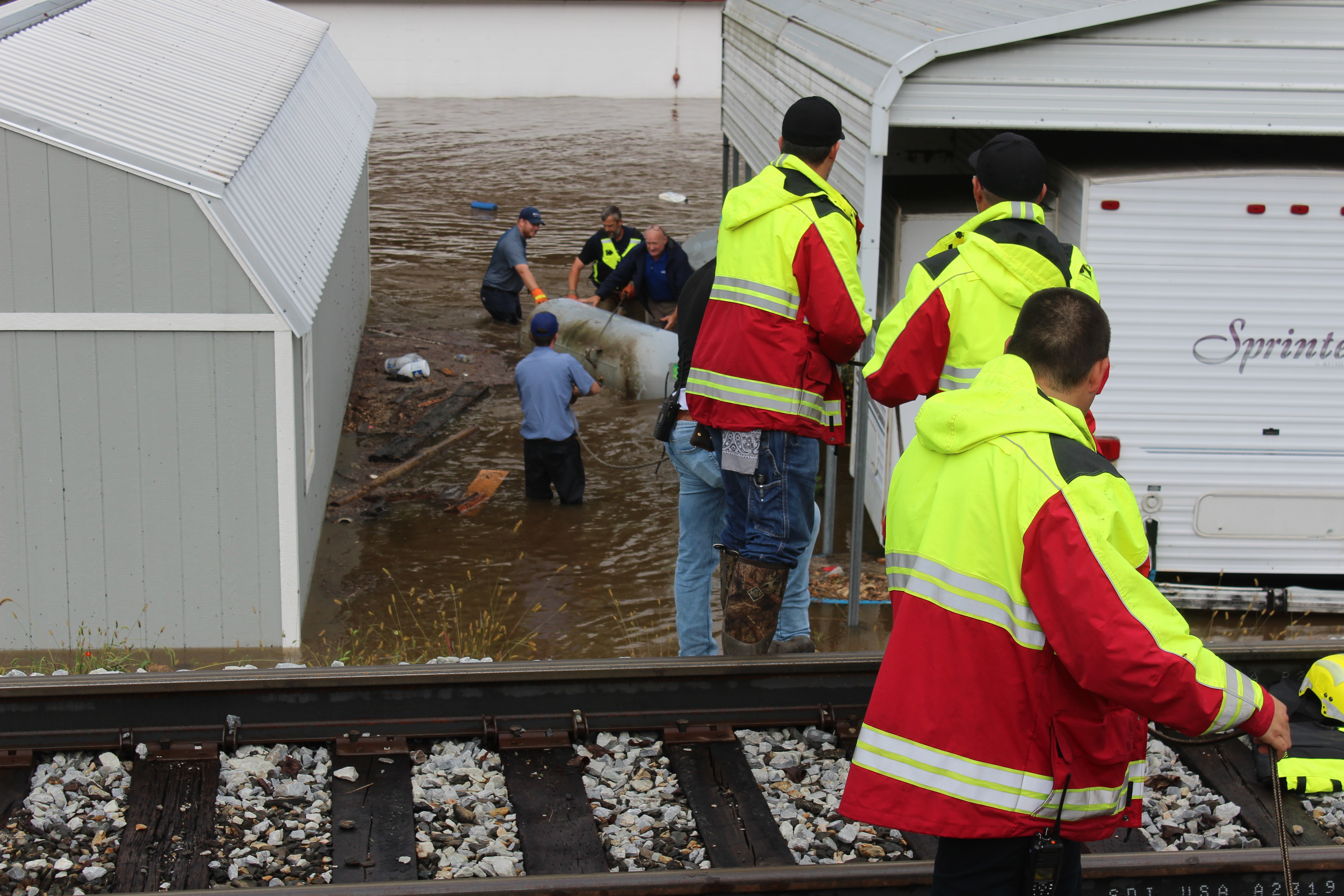 Tuckasegee River had flooded Country Girl's RV Park on Hyatt Creek Road with several feet of water by Friday morning. Above, rescue workers and workers from a local gas company pull a propane tank leaking from the water. 
