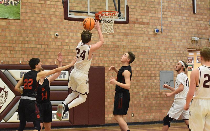 Maroon Devil Noel Wolf added 16 points for the Devils in the win over Rosman. Above, he goes for the net in the home loss to Franklin.