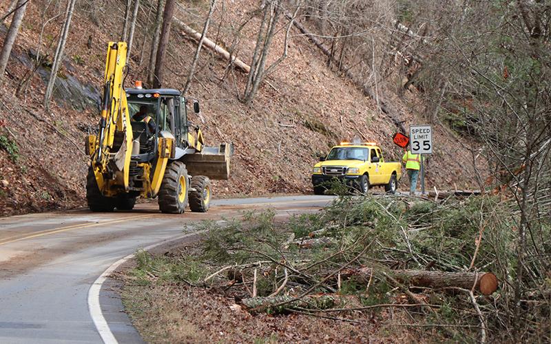 Workers with North Carolina Department of Transportation conduct storm damage clean up in the Grassy Branch community on Monday