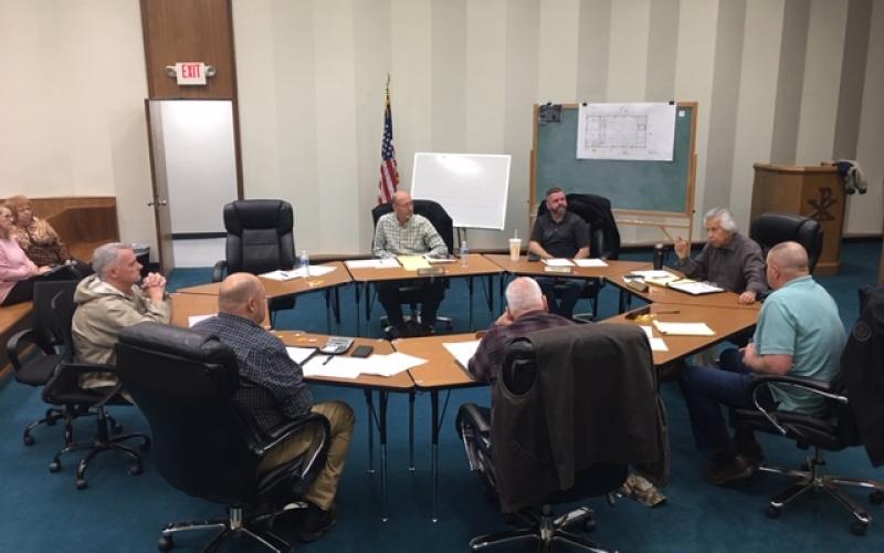 Commissioners meet around a round table to hear from department heads