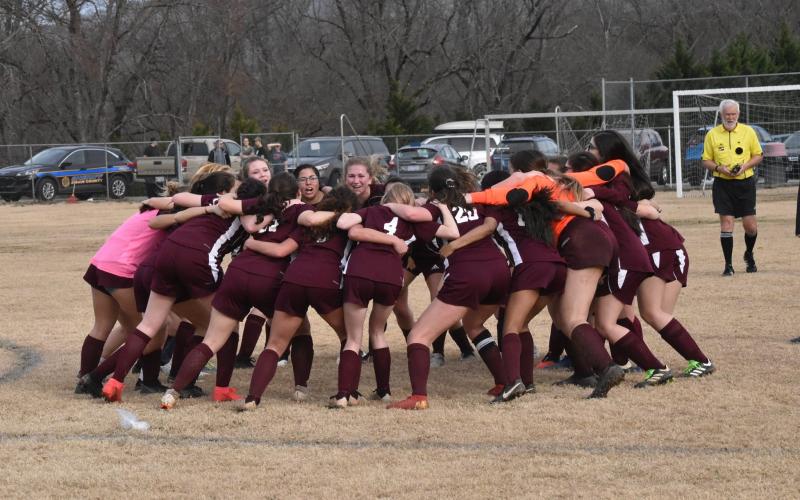 The Lady Devils soccer team has a huddle