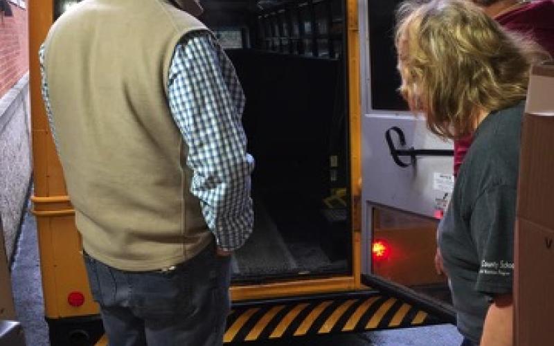 Staff loads the bus with student meals