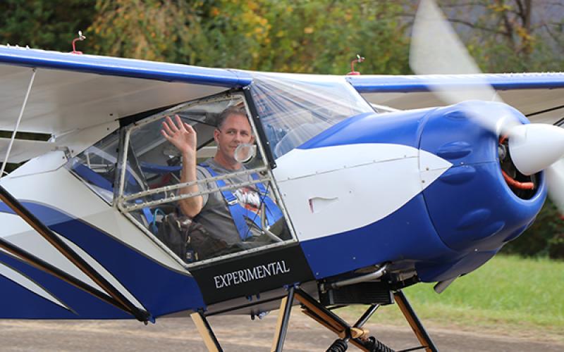 A pilot waves before taking off