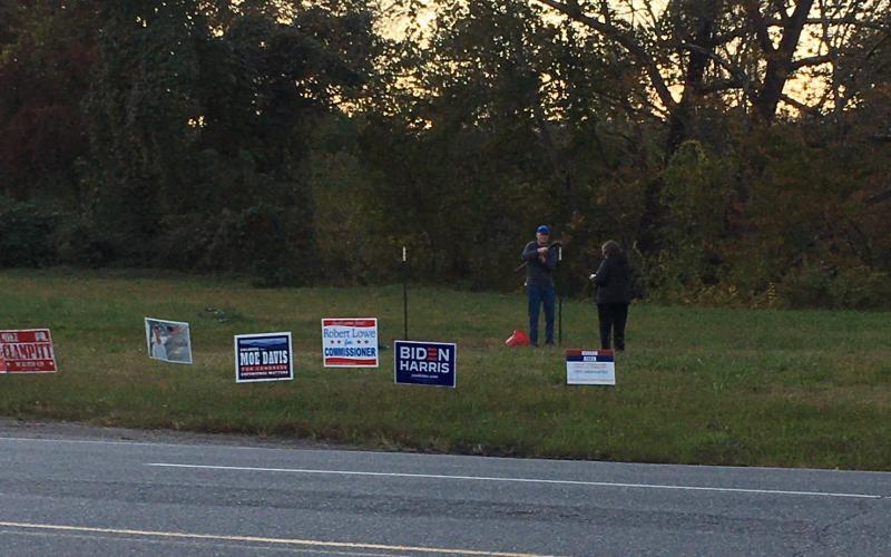 Democrats work to put up a large political sign across from Ingles