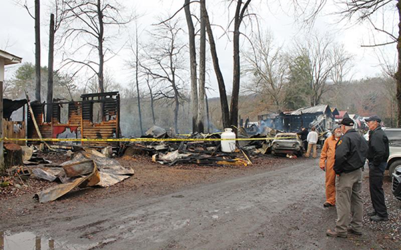 Fire investigators speak with the manager in front of two of the units that were a total loss
