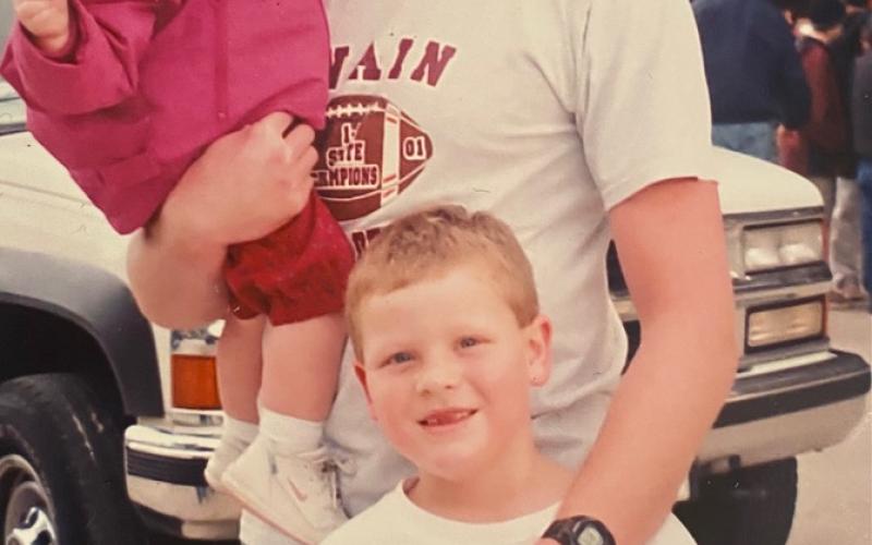 A very young Jenna is being held by Jeff with his son in the forefront