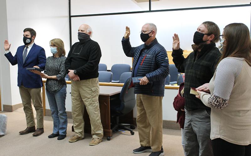 Gerald McKinney (incumbent, center), Mitchell Carson (right) and Cody White (left) took their oaths joined by members of their families