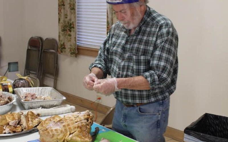 Volunteer Ken Jones helps divvy up the turkey.