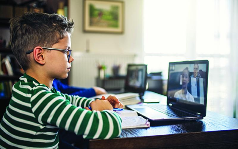 A boy works in front of a computer