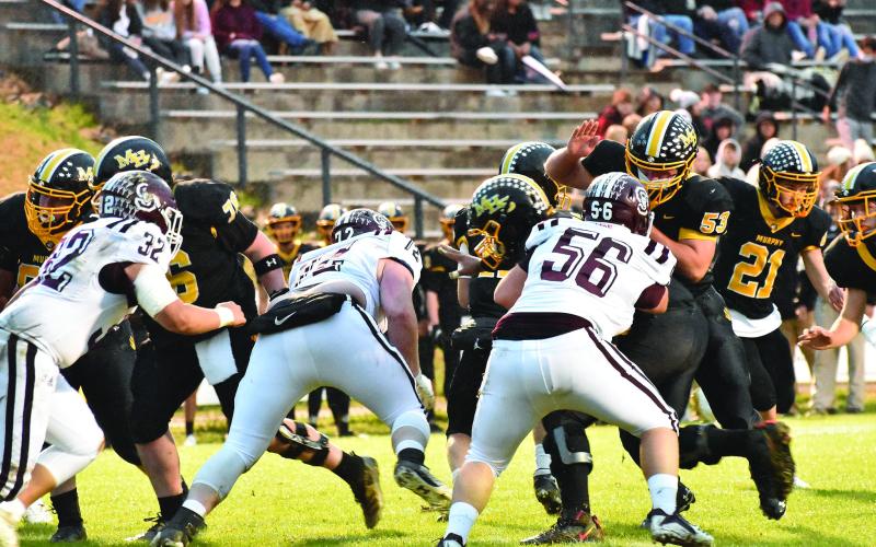 Swain’s Carson Taylor (32) Samuel Bernhisel (72) and Michael Winchester (56) defend the line against the Bulldogs.