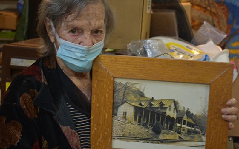 Juanita Lester holds a framed picture of her childhood home that was in the Bushnell community, one of several lost to the formation of Fontana Lake.