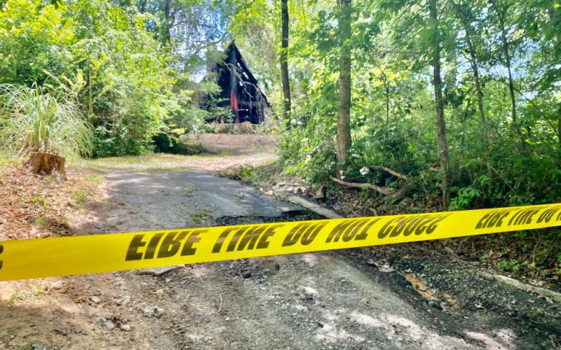 Crime tape blocks off the driveway to a house that was fully engulfed in flames in the early morning hours of June 1. Responders found a body inside the home after the fire was under control.