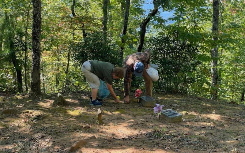 Karen Marcus and Henry Chambers place flowers on a grave