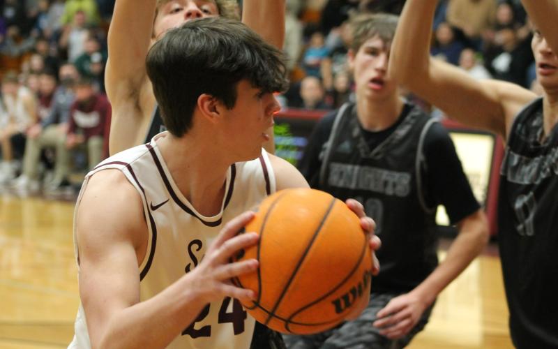 Nathan Bogdanowicz passes the ball to a teammate just as the Knights try to snatch it away in Tuesday night’s game.