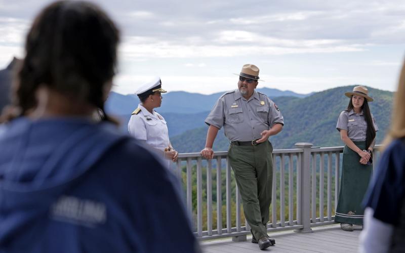 National Park Service Director Chuck Sams and Rear Admiral Denise Hinton speak to students and staff on National Public Lands Day Saturday.
