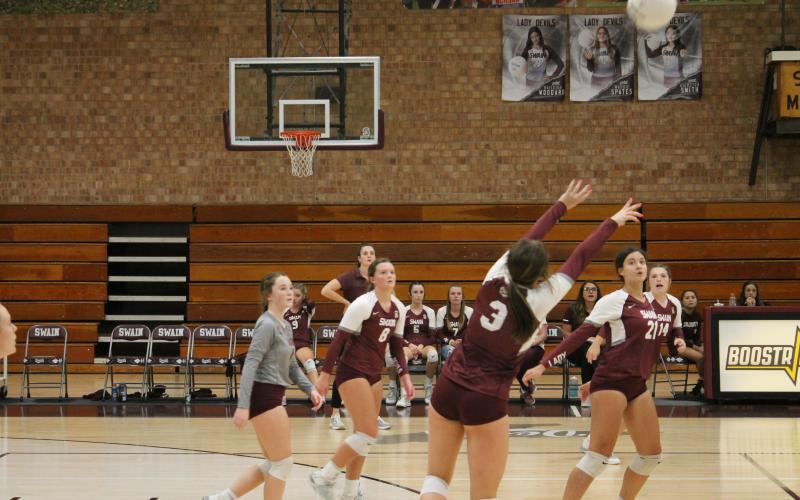 Lady Devil Kiersten Smith sets the ball as her teammates Haileigh Woodard and Rylee Rawls get ready for a spike.
