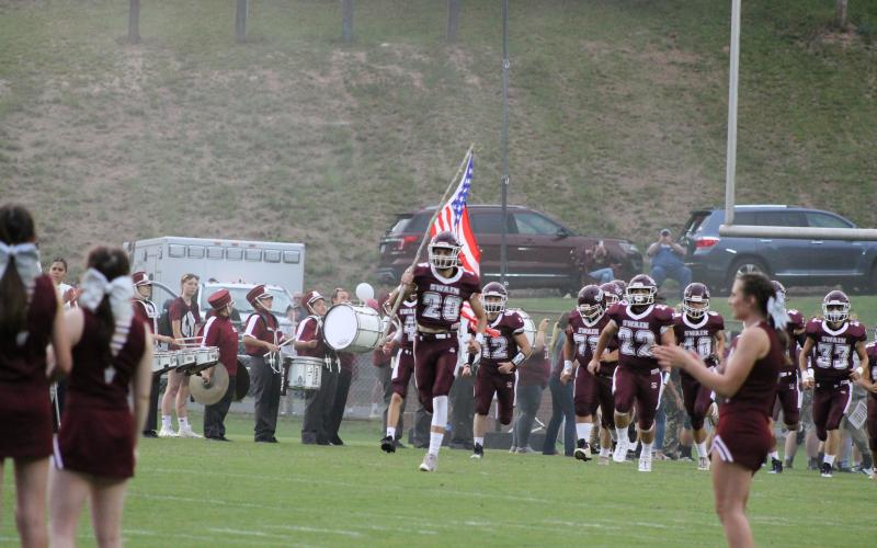 The Maroon Devils got hyped up as fans, cheerleaders, and the marching band lined the field as Maroon Devil Cole Wikle led the charge carrying an American flag as his teammates bust through the banner onto the field.