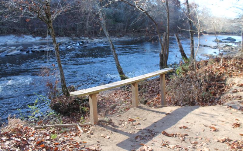 Erosion is obvious at this bench overlooking the river where the earth falls away at the edge of the bench.