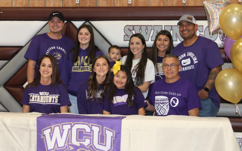 Swain senior Amaya Hicks signs to run at WCU. She's surrounded by family at a ceremony held last week at Swain.
