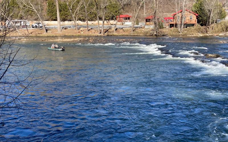 A fishing boat floats on the Tuckasegee River near the Governor's Island bridge.