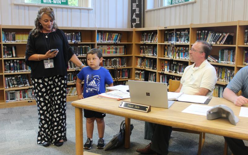 West Principal Lisa Sutton (left) recognizes student Christoph Ensley for good character at the Monday, Sept. 11 school board meeting, held at the middle school media center.