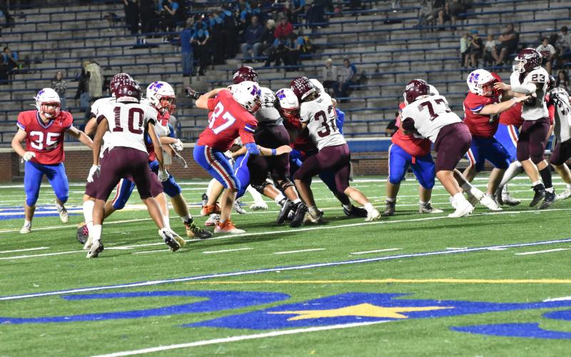 Keyanthae Graham (from left), Mason Cochran, Andreas Cisneros and Skeet Cook grapple with opponents from the Madison Patriots at the game Sept. 22. The Devils won in 35-16.
