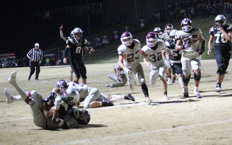 Maroon Devils sophomore Skeet Cook (from left), junior Mason Cochran and sophomore Drew Skaggs run toward the action at the away game in Robbinsville on Friday, Nov. 17