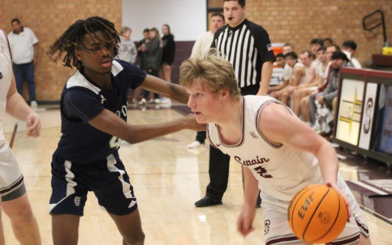 Senior Josh Collins maneuvers the ball around an opponent’s tenacious defense.