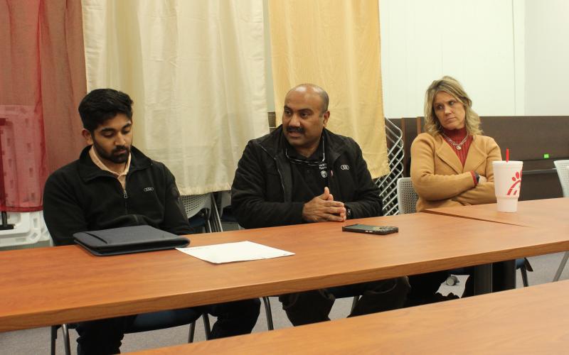 Mark’s Pharmacy owner Mark Adam (center) sits with his son Faisal Adam and pharmacy partner Christy Kirkpatrick at the town hall meeting at the library Thursday, Feb. 8.