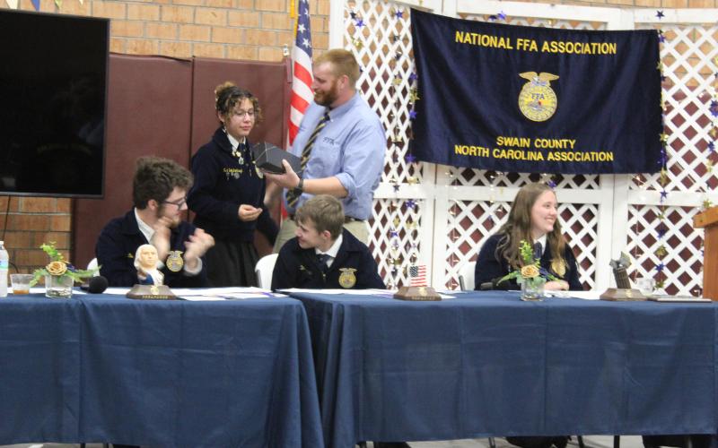 Toby Sorrell presents FFA President Eva Bottchenbaugh with an award