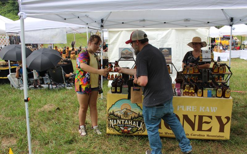 A patron gets a sweet taste of local gold from Nantahala Honey Company.