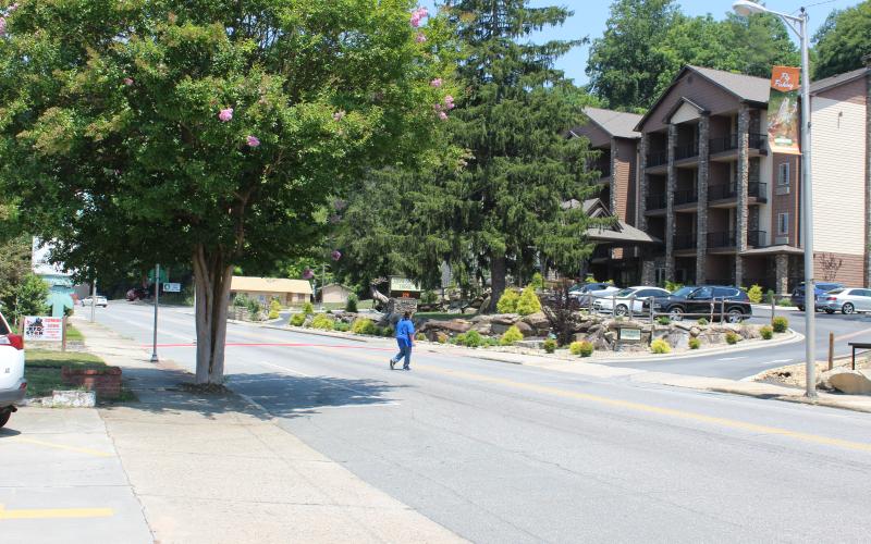 A pedestrian crosses Main Street toward Stonebrook Lodge. The Bryson City Planning Board has identified this section of Main Street as the best area to direct limited grant funding toward sidewalk repairs, in part because most of the utilities under the sidewalks have been upgraded unlike on the other side of the road toward Veterans Boulevard.