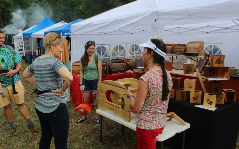 A woodcrafter at the event demos a unique seat for toddlers.