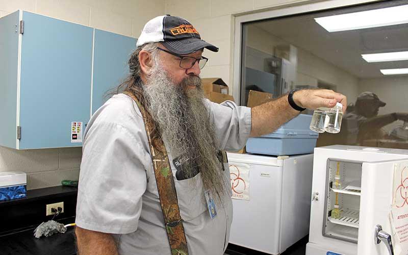 Jessica Webb/SMT - Russell Ball, director of the town water plant, holds up samples of the finished water. The plant frequently conducts a variety of tests on the water at various stages of the process.