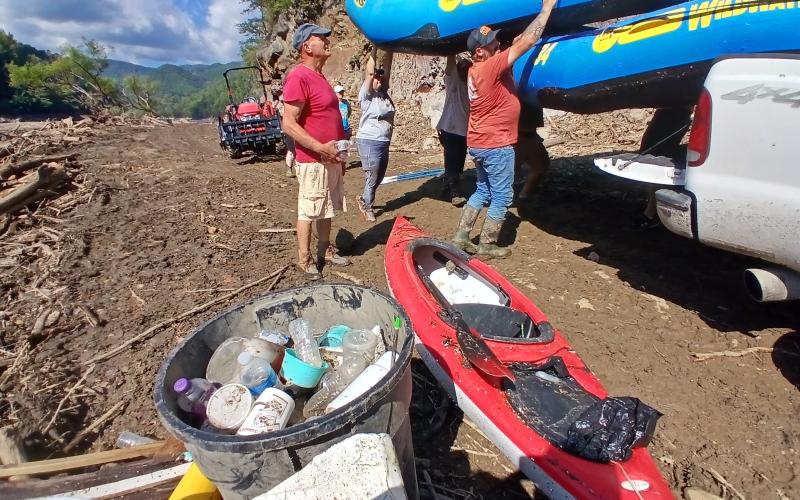 Volunteers unload rafts to put in the water to continue collecting trash and debris.