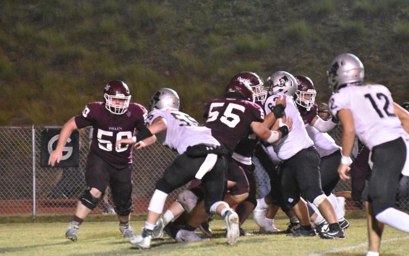 From left, Maroon Devil defense Noah Brown (50) and Drew Scaggs (55) slow the Black Knights down during the home game this past Friday.