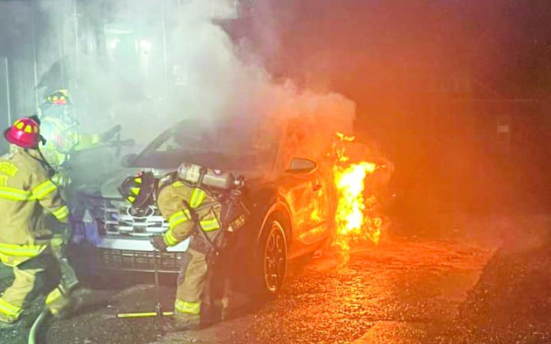 Firefighters prevented the flames of a car fire from threatening the house it was parked next to.