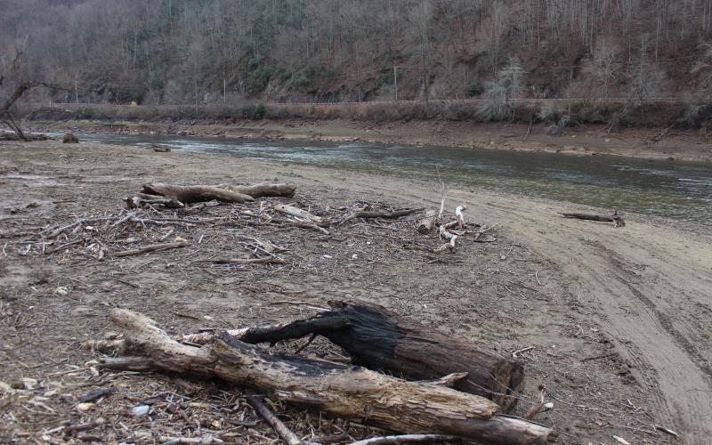 Piled up wood storm debris fills the exposed riverbed next to the 288 boat ramp.