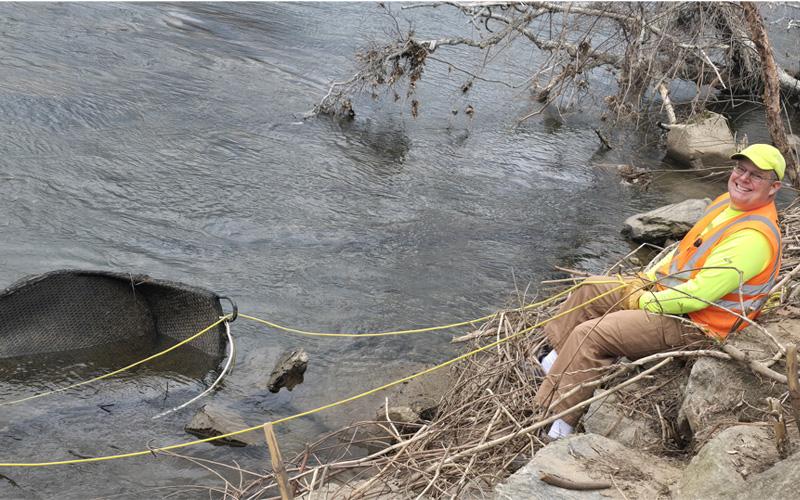 Photo/Sara Eisinger. Swain Clean Co-chair Tom Womble spends his morning retrieving a wicker couch swing from the Tuckasegee River behind the pavilion on Saturday, March 15. A little spring rain could not stop nearly a dozen Swain Clean volunteers from picking up around the river and roadways.