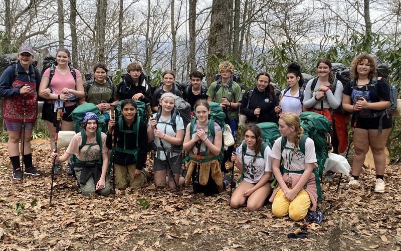 Submitted photo.  Mountain Discovery Charter School seventh grade students Rain (front, left to right), Mia, Maisy, Stella, Gaia and Alaina; (back, left to right) Aaliyah, Sara, Ryver, Trent, Novi, Nasseem, Miracle, Olivia, Vanessa, Olivia and Charlie take to the woods Wednesday, April 2, ending their excursion Friday, April 4. Approximately 150 field trips take place per year.