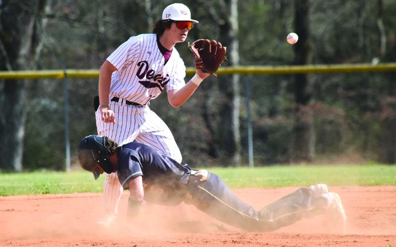 Photo/ Joanna McMahan.  Will Holden keeps his eye on the ball as a Hayesville player dives for the base on Friday, March 28.