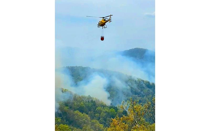 Photo/Doug Cochran.  Helicopters take off from West Swain Elementary School to fight the Sam Davis Fire Monday, April 21. The cause of the fire is unknown and remains under investigation.